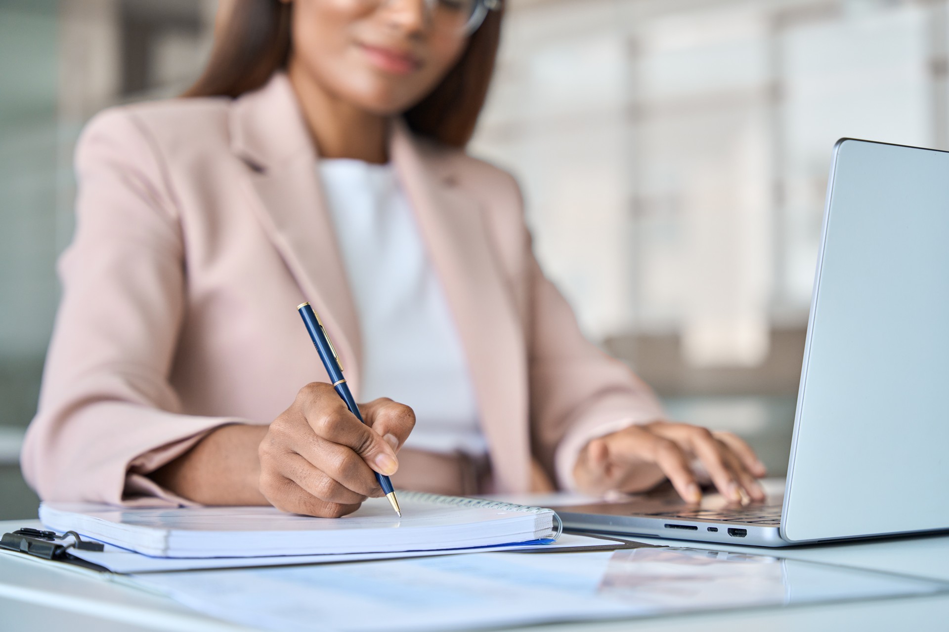 Close up view of professional business woman working writing notes in notebook.